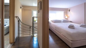 Ein Hotelzimmer mit Bett, Badezimmer und einer Treppe.