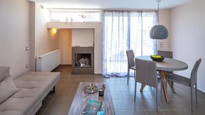 Ein modernes Wohnzimmer mit einer Couch, einem Couchtisch und einem Essbereich mit Stühlen und einem Tisch.
