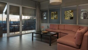 A modern living room with a sofa, a coffee table, and abstract wall art. - Virgo - Loft with Spectacular View to Acropolis (Athina)