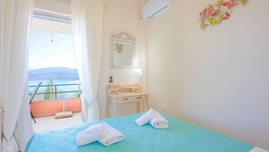 Ein Schlafzimmer mit Bett, Schminktisch und Blick ins Freie.