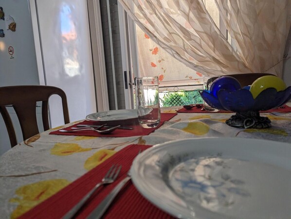 A dining table with a plate, glass, and utensils.