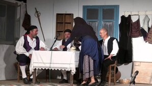 Un escenario con una mesa, sillas y un micrófono.