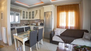 Un espacio habitable compacto con kitchenette, comedor y sofá.