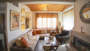 Una sala de estar con sofá, sillones, una mesa de centro y una chimenea.