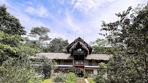 A traditional thatched-roof building with a central staircase leading to a balcony. - Superior Quadruple Room Suchipakari Jungle Lodge (Napo)
