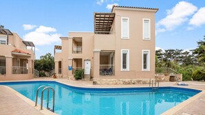 A residential building with a swimming pool, balconies, and a stone pathway. - Villa Blue Dreams in Maleme (Maleme)