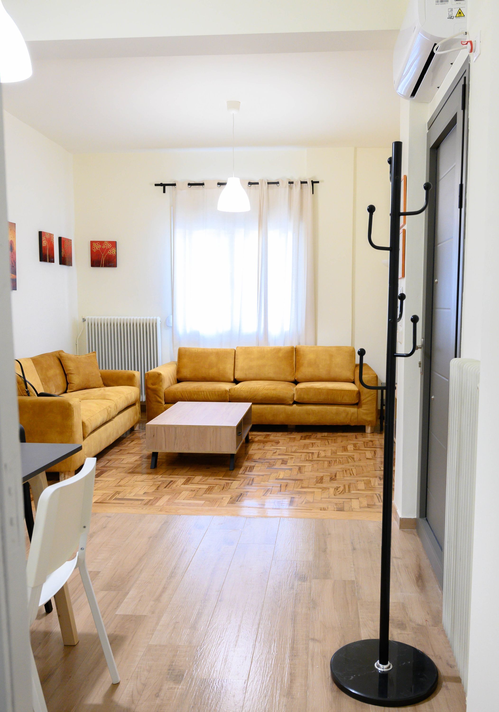 A living room with a sofa set, a coffee table, and a radiator.