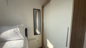 A bedroom with a bed, a mirror, and a wardrobe. - Central Horsham Flat | Free Parking (Horsham)