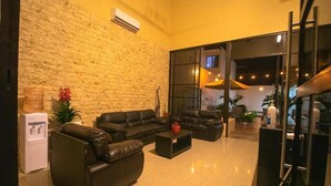 A modern living room with leather sofas, a coffee table, and a water dispenser. - Hotel Avila (Valladolid)