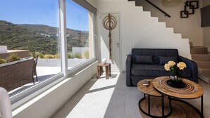Ein modernes Wohnzimmer mit gro ßem Fenster, einer Couch, einem Couchtisch und einer Treppe.