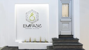 Een witte muur met een logo en tekst voor "EMFASIC LUXURY VILLAS".