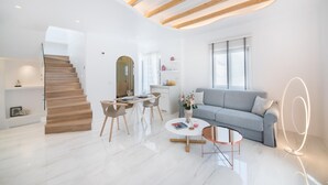 Een moderne woonkamer met een trap, een eethoek en een bank.