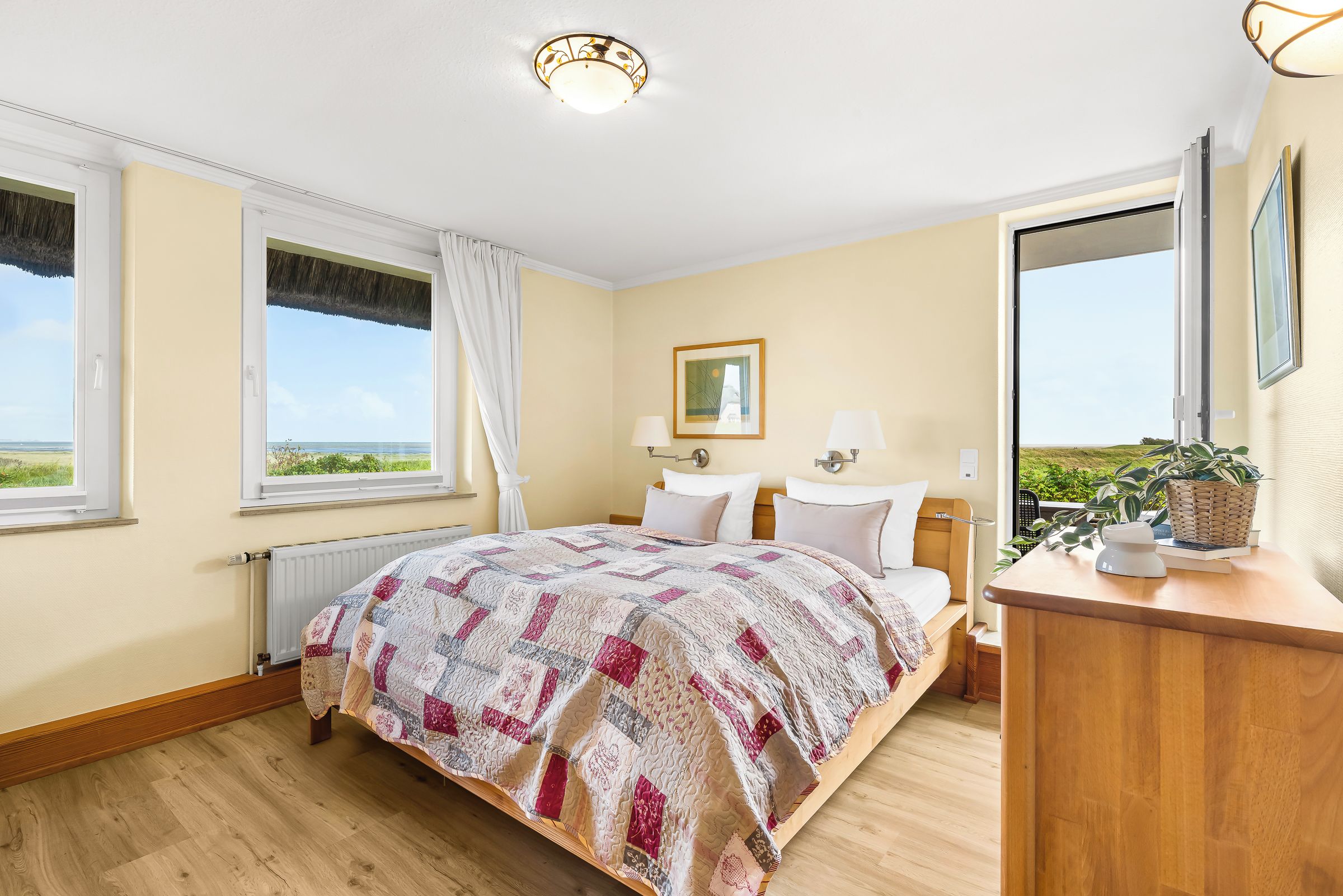 Un dormitorio con una cama grande, una mesita de noche, una ventana con vistas y una lámpara en el techo.