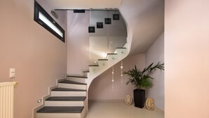 En moderne trappe med glasgelændere og et buet design.