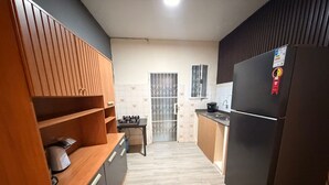A kitchen with a wooden cabinet, a black refrigerator, and a tiled backsplash.