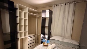 A bedroom with a bed, a wardrobe, and a bathroom.