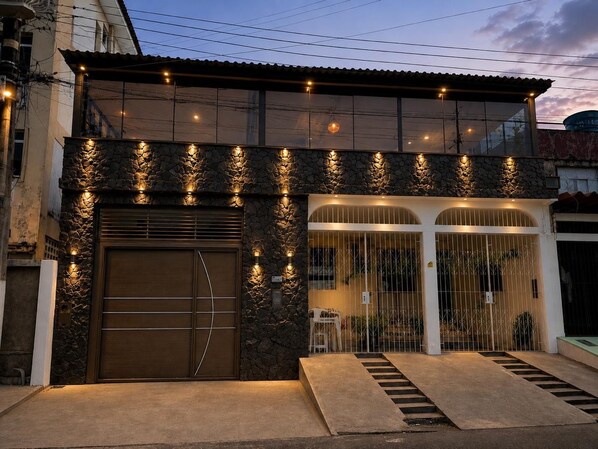 A building with a stone facade, a large garage door, and a gated entrance with a staircase leading up.