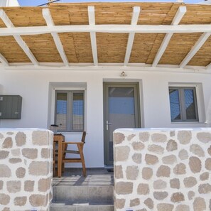 A covered outdoor seating area with stone walls and a wooden ceiling. - Dream on  Adamas Milos (Adamas)