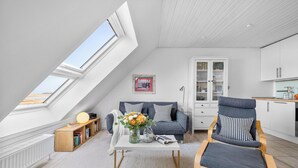 A loft-style living room with a sloped ceiling, a dining area, and a kitchen. - Modern beachfront apartment in Stein with exceptional sea view and terrace (Stein)
