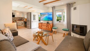 Ein modernes Wohnzimmer mit einem Glastisch, einer Couch und einem Fernseher.