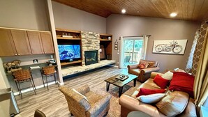 A modern living room with a fireplace, leather sofas, a coffee table, and a TV. - Cozyville Cabin: Quiet Getaway, Built 2019 (Big Bear)