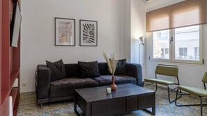 Ein Wohnzimmer mit einem dunkelbraunen Sofa, einem Couchtisch und zwei gerahmten Kunstwerken an der Wand.