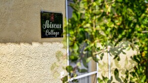 Ein Schild mit der Aufschrift 'Abissus Cottage' an einer strukturierten Wand.