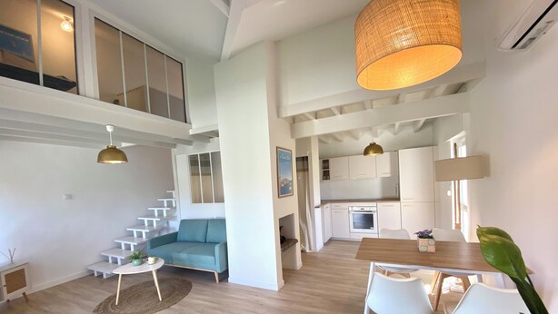 A modern apartment with a living room, dining area, kitchen, and a staircase leading to an upper level. - Cosy, quiet house close to the oyster port. (La Teste-de-Buch)