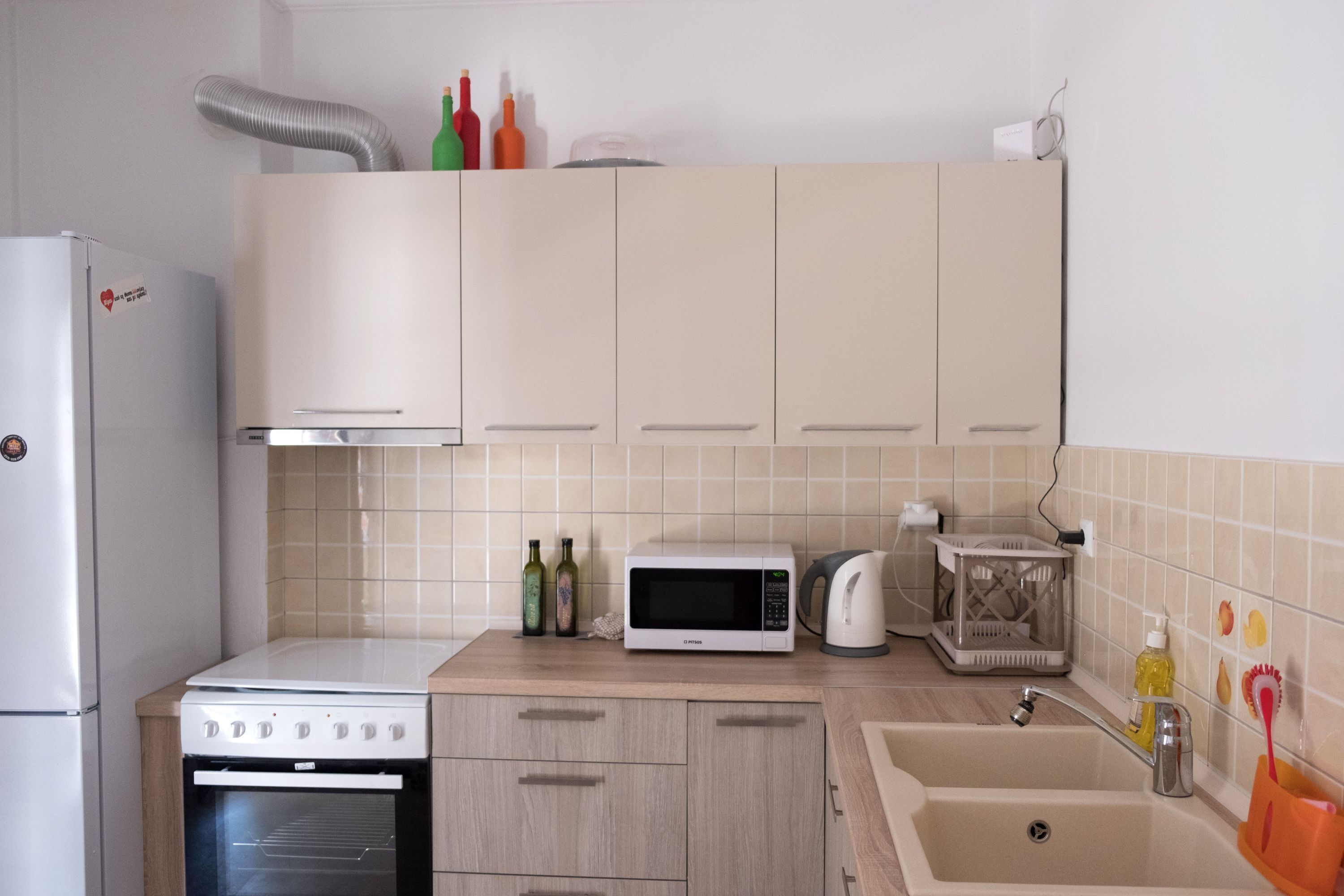 Una cocina equipada con estufa, microondas, horno, pileta y alacenas.