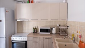 A kitchen with a stove, microwave, oven, sink, and cabinets. - ALPHA OMEGA   suite (ΑΩ) (Thessaloniki)