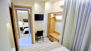 A hotel room with a bed, a desk, a chair, a wardrobe, and a television on the wall. - Suite Mariengela - Demar Suites (Vlicho)