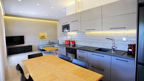 A modern kitchen with grey cabinets, a black countertop, and a built-in oven. - Suite Mariengela - Demar Suites (Vlicho)
