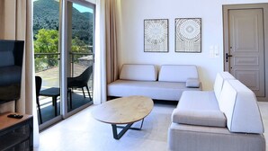 A modern hotel room with a wooden ceiling, a sofa, a TV, and a balcony with a view of the mountains. - Suite Demi - Demar Suites (Vlicho)