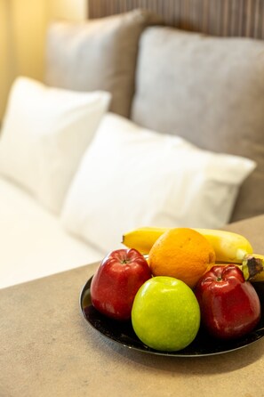 Un panier de fruits est posé sur une table, et il contient des pommes, une orange et une banane.