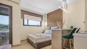 Een moderne slaapkamer met een bed, een bureau en uitzicht op de stad.