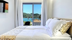Une chambre d’hôtel avec un lit, une télévision et une vue sur un paysage montagneux.