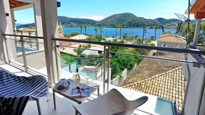 Un balcon avec vue sur un lac, des montagnes et une piscine.