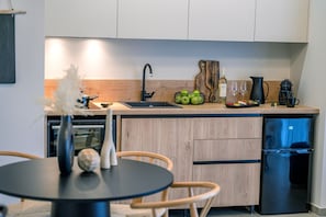 Cocina moderna con encimera de madera, un fregadero y un refrigerador negro.