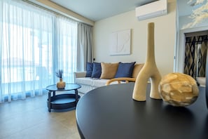 Una sala de estar moderna con un sofá, una mesa redonda y un jarrón decorativo.