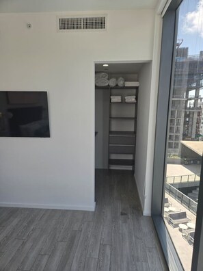 A room with a large window, a built-in closet with shelves, and a wooden floor. - Miami-Brickell Luxury 2BR-2BATH with skyline VIEWS (Miami)