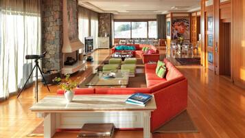 A spacious living room with a red sofa, a coffee table, and a stone fireplace.