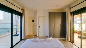 A hotel room with a bed, a door, and a view of the outside balcony. - Ben Yehouda Obsidian (Tel Aviv-Yafo)