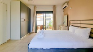 A hotel room with a large bed, a bedside table, a mirror, and an air conditioning unit. - Ben Yehouda Obsidian (Tel Aviv-Yafo)