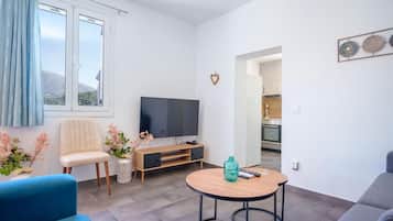Ett modernt vardagsrum med en tv, en soffa och ett litet bord.