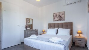 Un dormitorio con una cama grande, mesitas de noche, un aparador y un espejo.