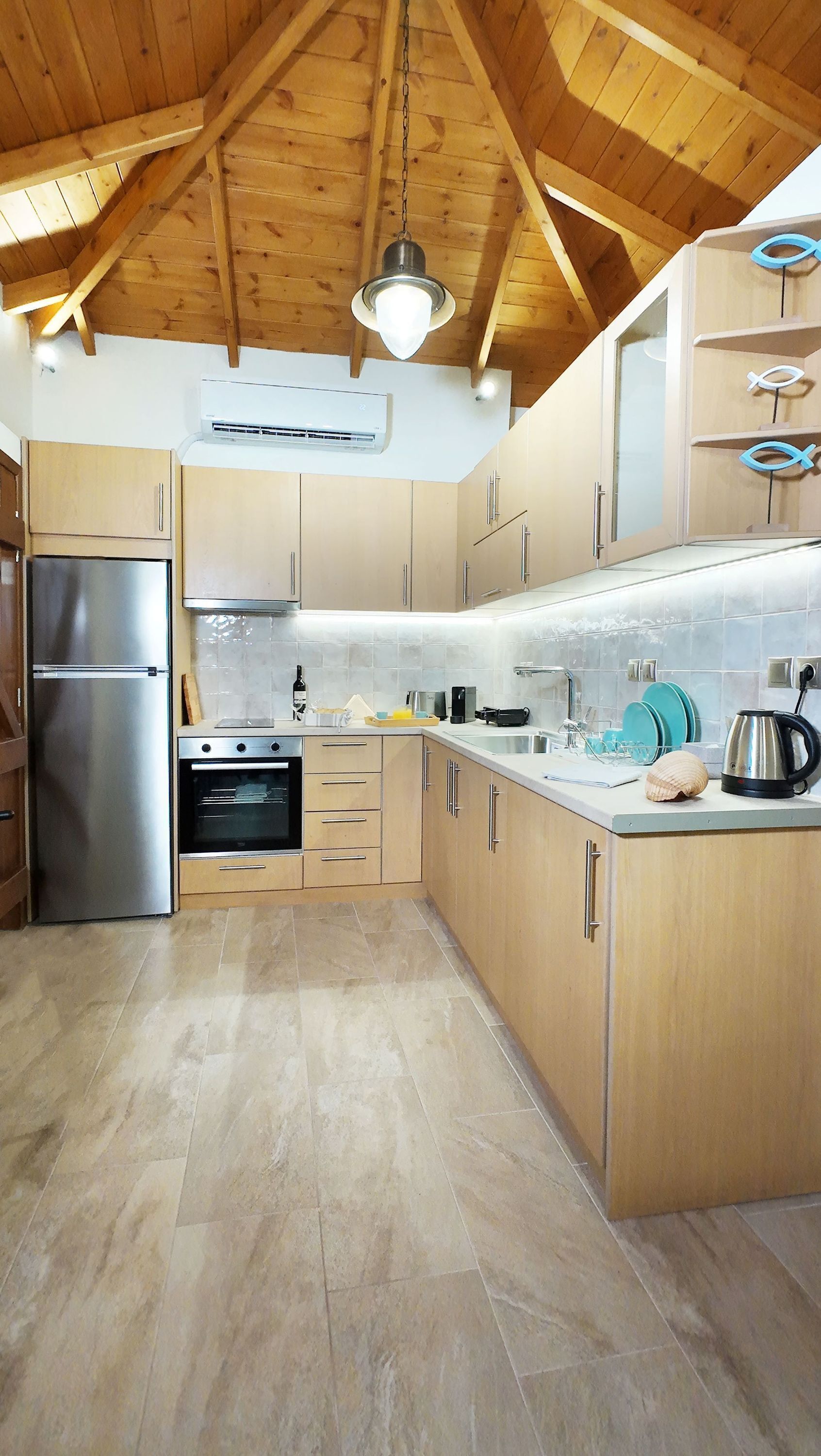 Une cuisine moderne avec des meubles en bois, des appareils électroménagers en acier inoxydable et un dosseret carrelé.