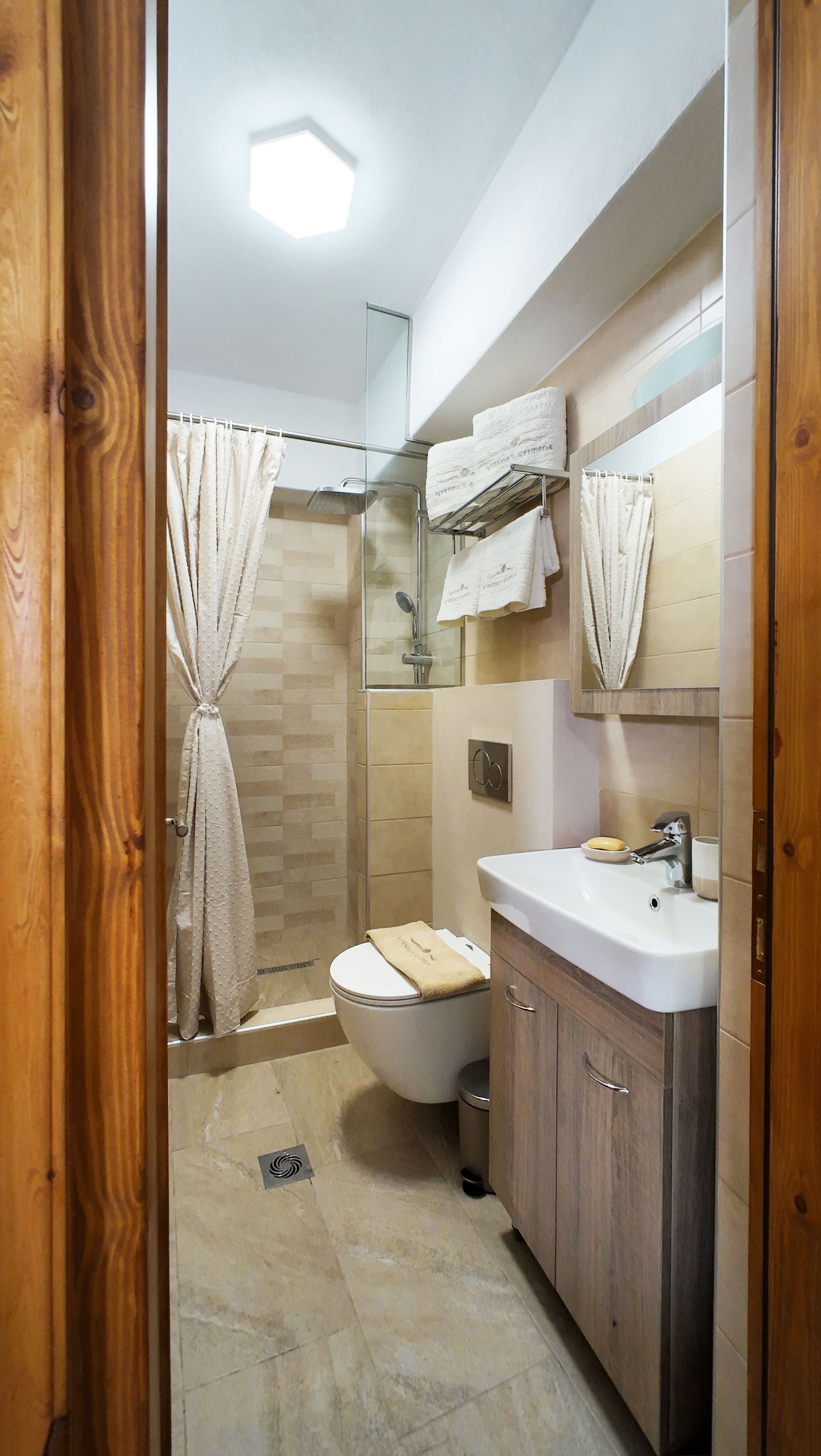 Een badkamer met een douche, toilet en wastafel.
