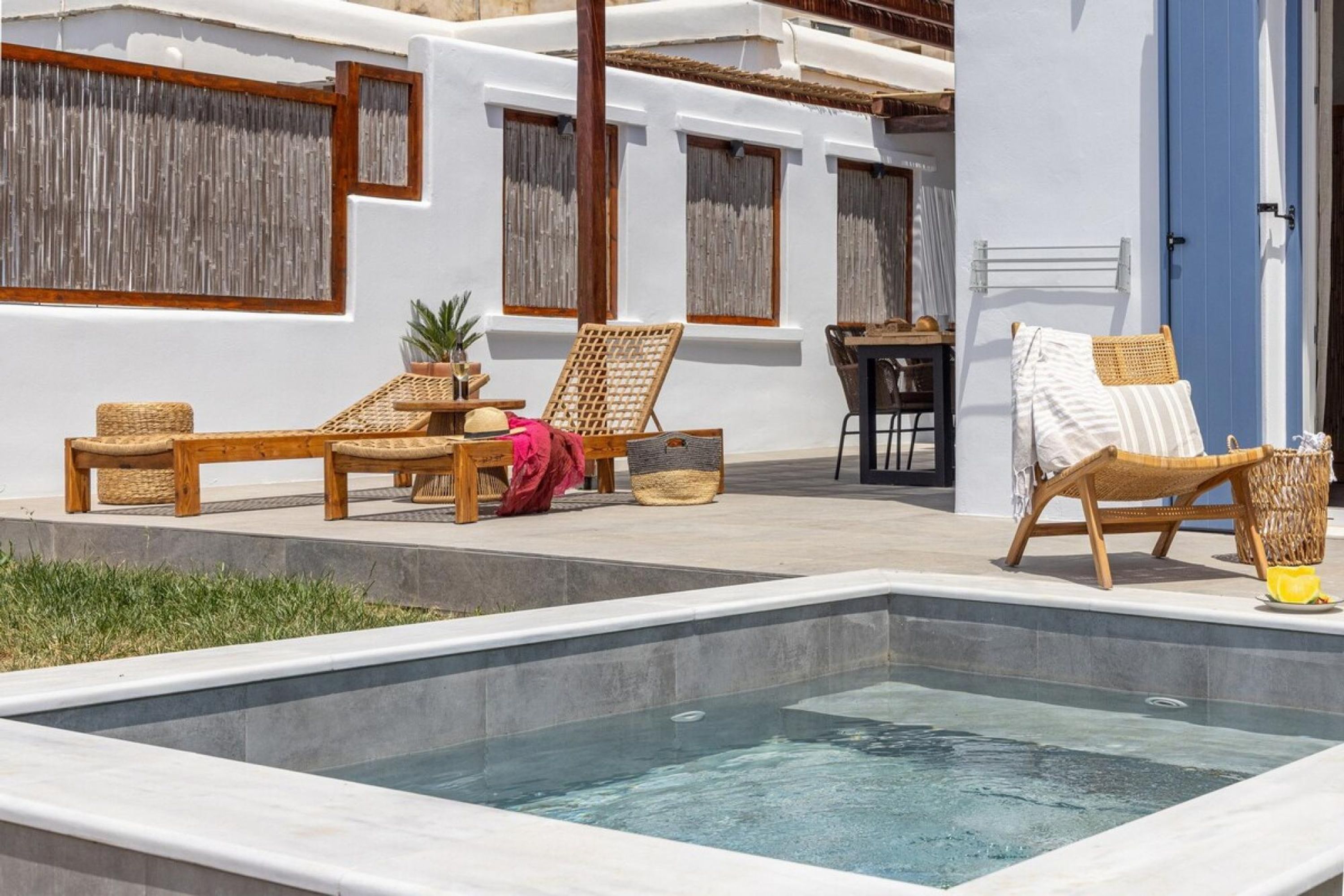 A pool area with lounge chairs and a table.