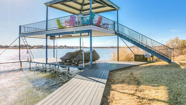 Un muelle con una zona de estar cubierta y una escalera que lleva a una plataforma.