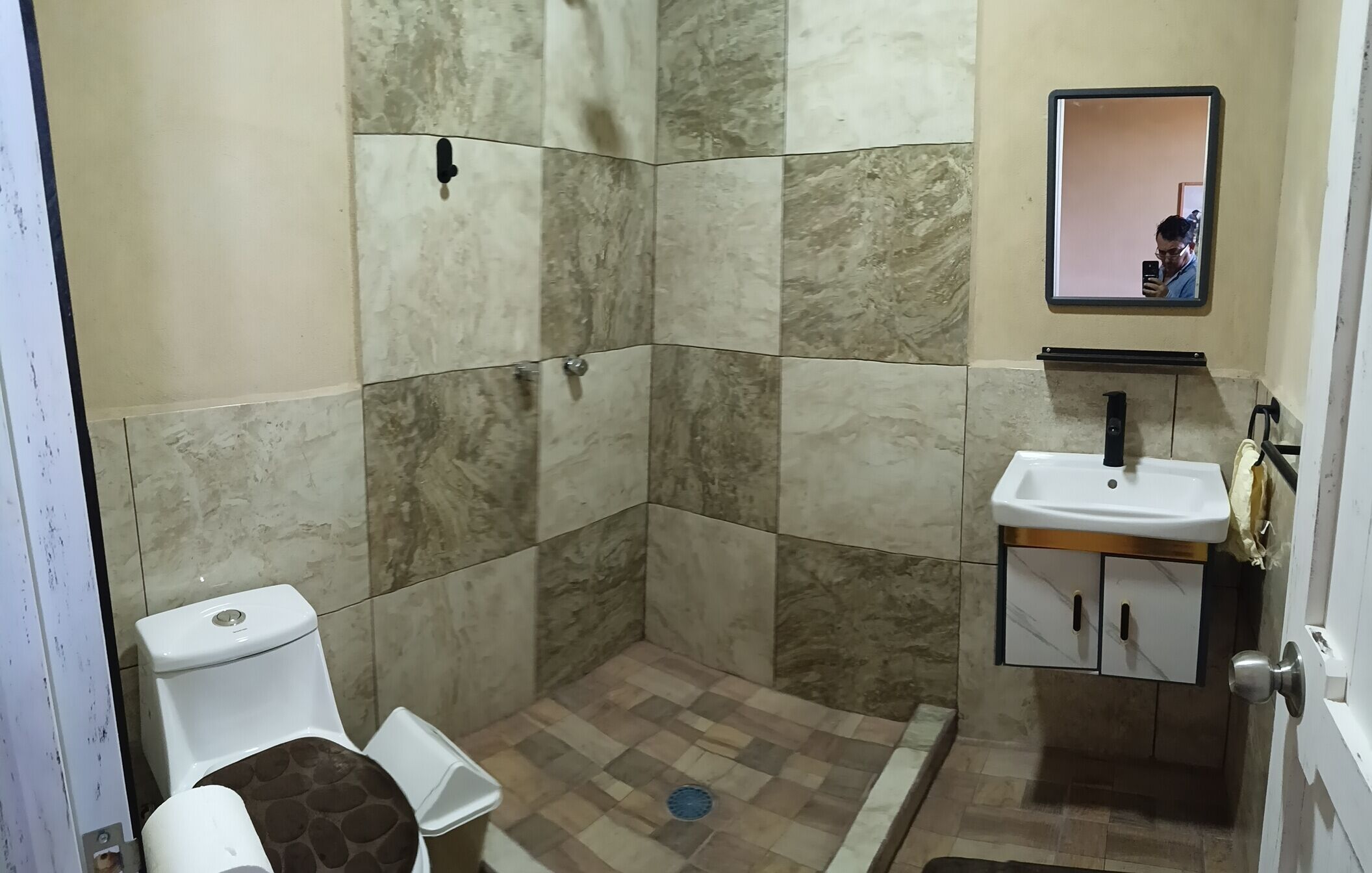 A bathroom with a toilet, shower, and sink.